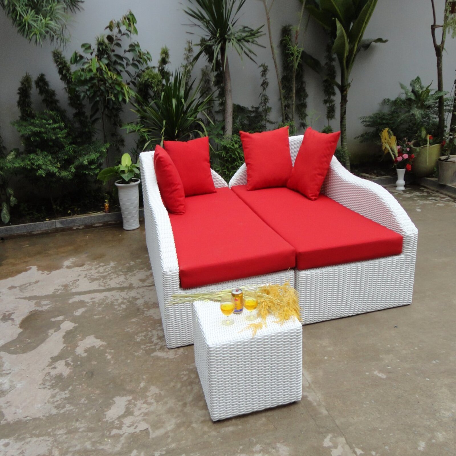 POOL AND GARDEN DOUBLE CHAIRS OR DAY BED WITH A UNIQUE ROMANTIC RED CUSHION MADE OF RATTAN .