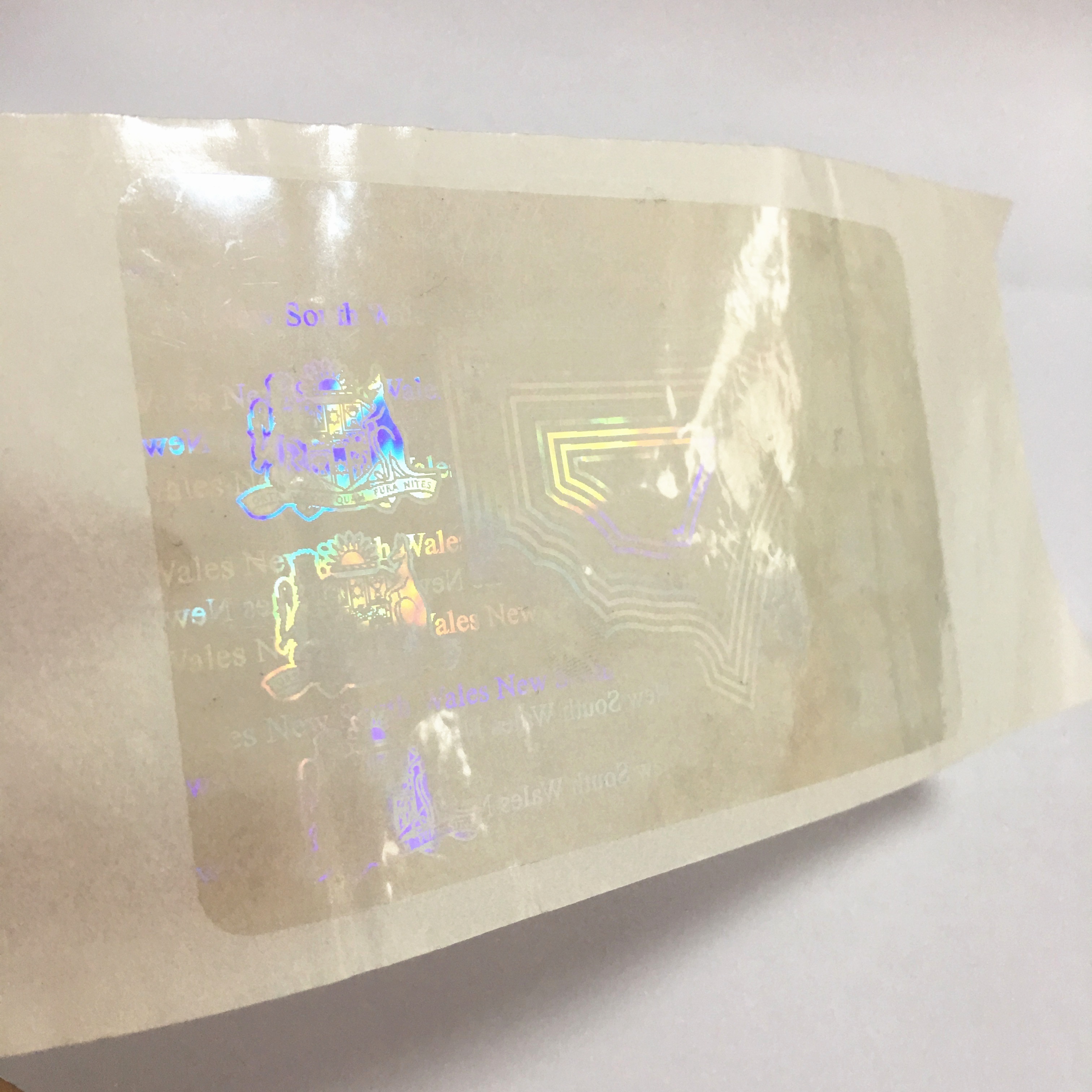 Anti-counterfeiting nsw transparent overlay hologram with custom logo