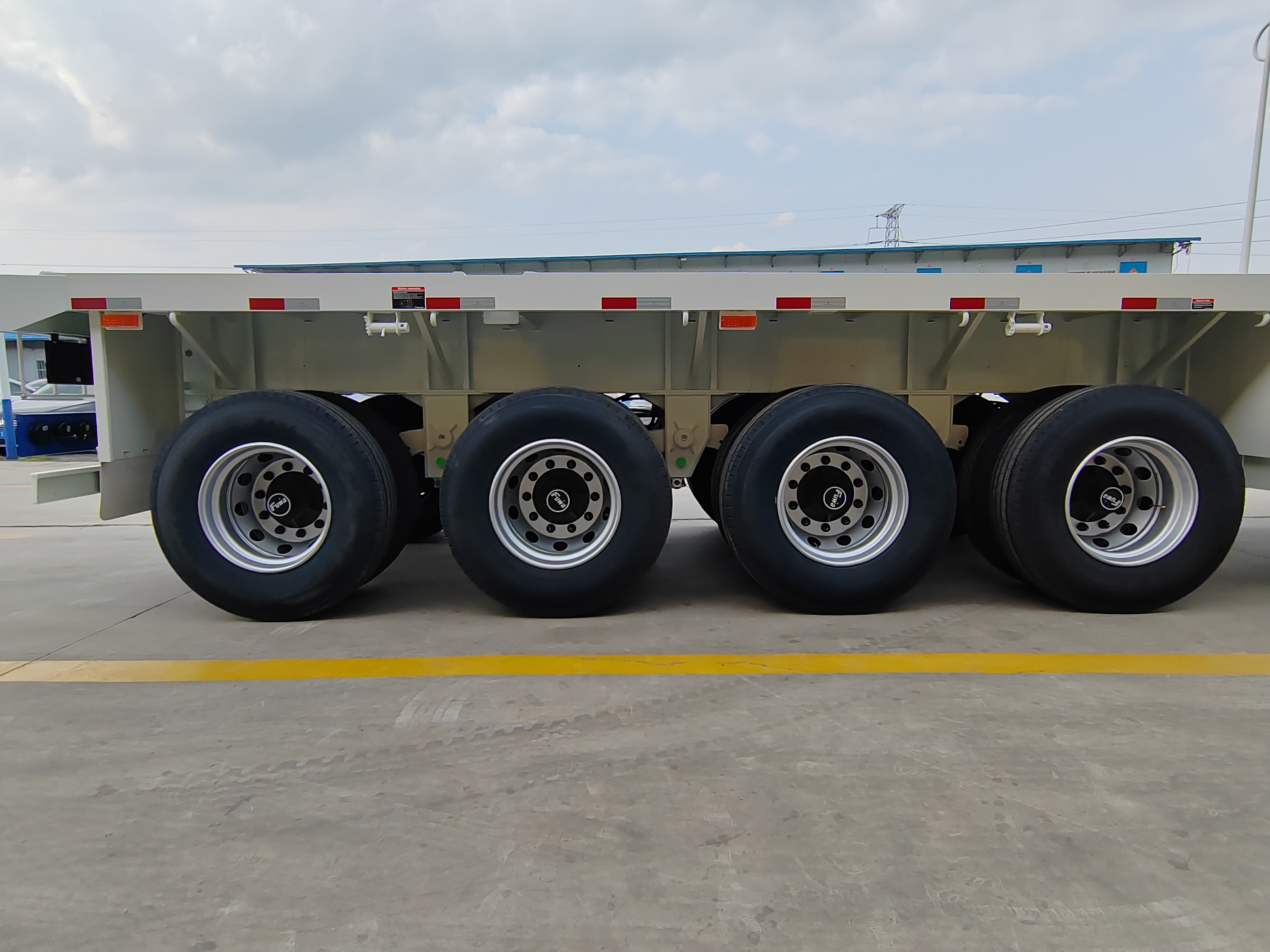 JianXing Factory provide 4 Axles 13m 40ft 60tons 12 twist Locks Flatbed Trailer Flatbed Container Chassi Trailers