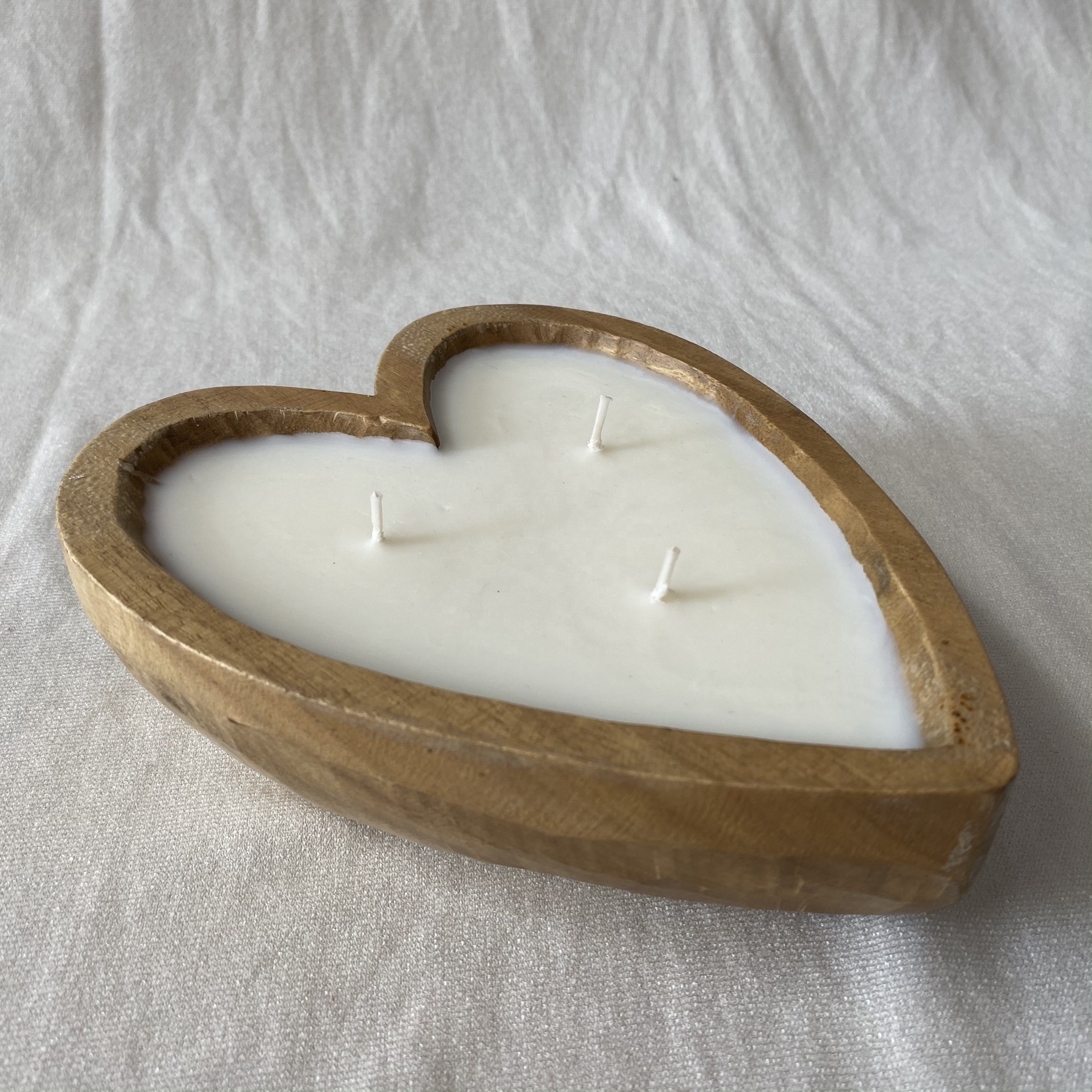 Hand-poured vanilla scented candles in hearted shape wooden bowls from Vietnam