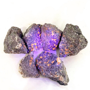 Natural rough crystal healing stone rocks under ultraviolet light flash yooperlite raw stone