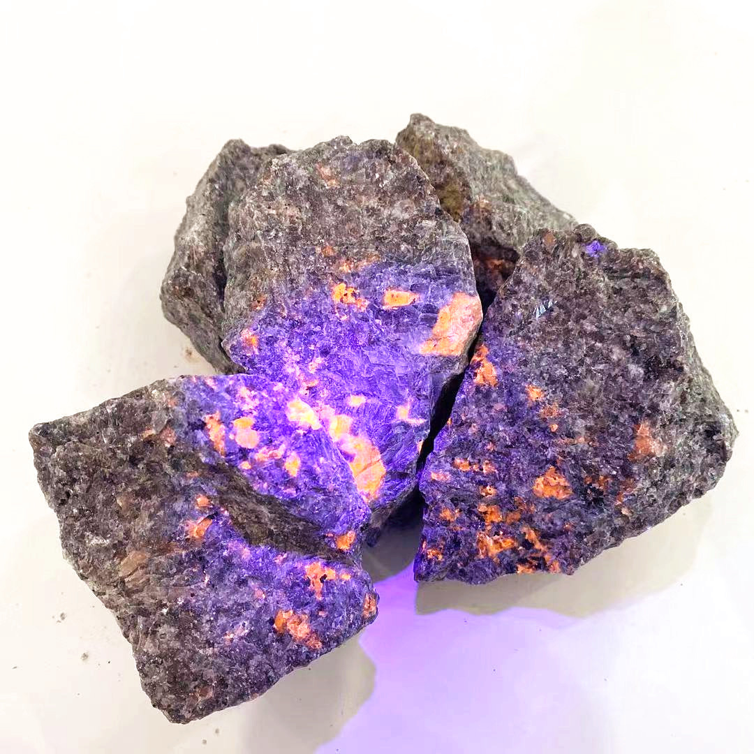 Natural rough crystal healing stone rocks under ultraviolet light flash yooperlite raw stone