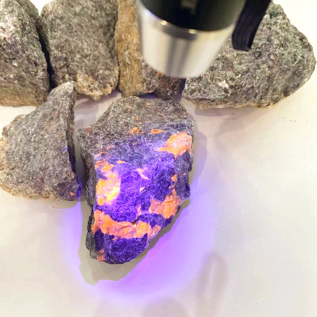 Natural rough crystal healing stone rocks under ultraviolet light flash yooperlite raw stone