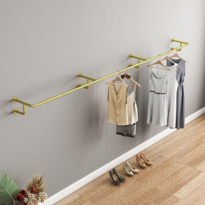 Metal Golden Clothing Display Rack On Wall Side Hanger In Modern Boutique Clothing Store