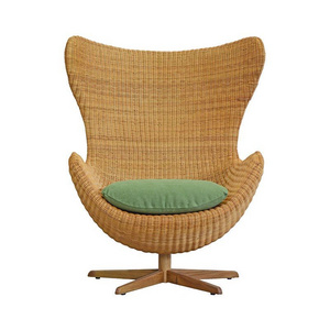 Bwuana egg lounge chair made from rattan and solid teak wood legs with natural oil finish for indoor and outdoor.