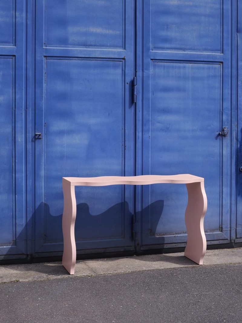 Agatha solid teak wood console table with a wavy shape with a natural finish.