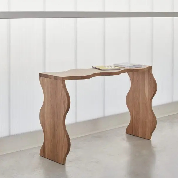 Agatha solid teak wood console table with a wavy shape with a natural finish.