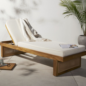 Varicha outdoor chaise chair made from solid teak wood frame and woven rattan legs with thick, water-repellent padding.