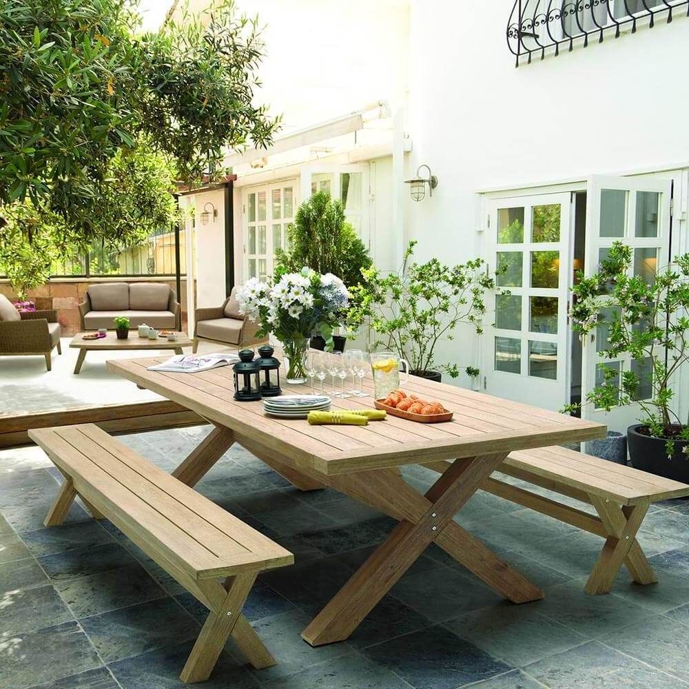 Riyan set of garden picnic benches made of solid teak wood with natural finish.