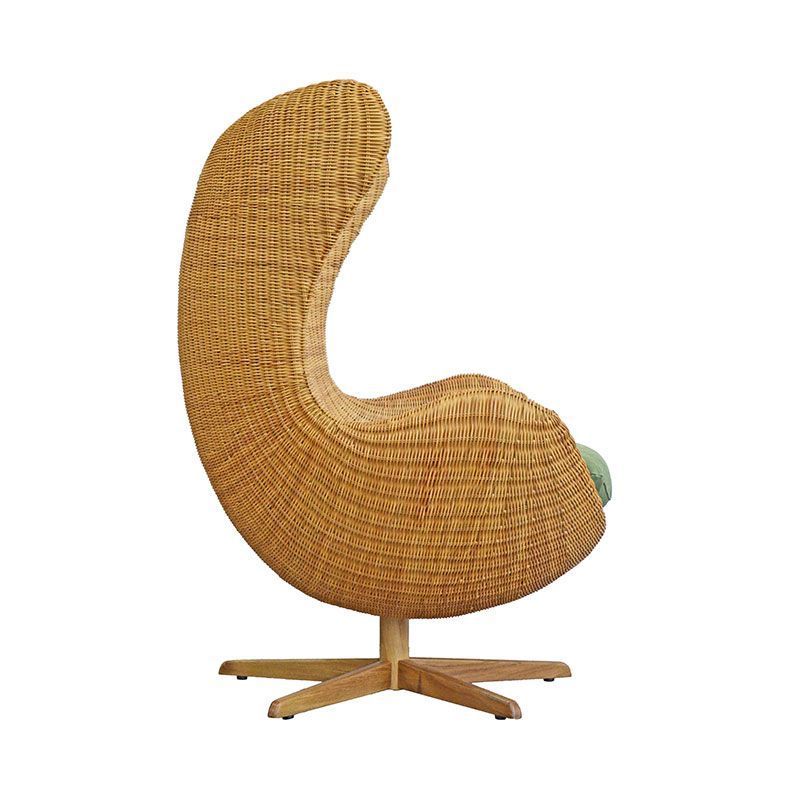 Bwuana egg lounge chair made from rattan and solid teak wood legs with natural oil finish for indoor and outdoor.