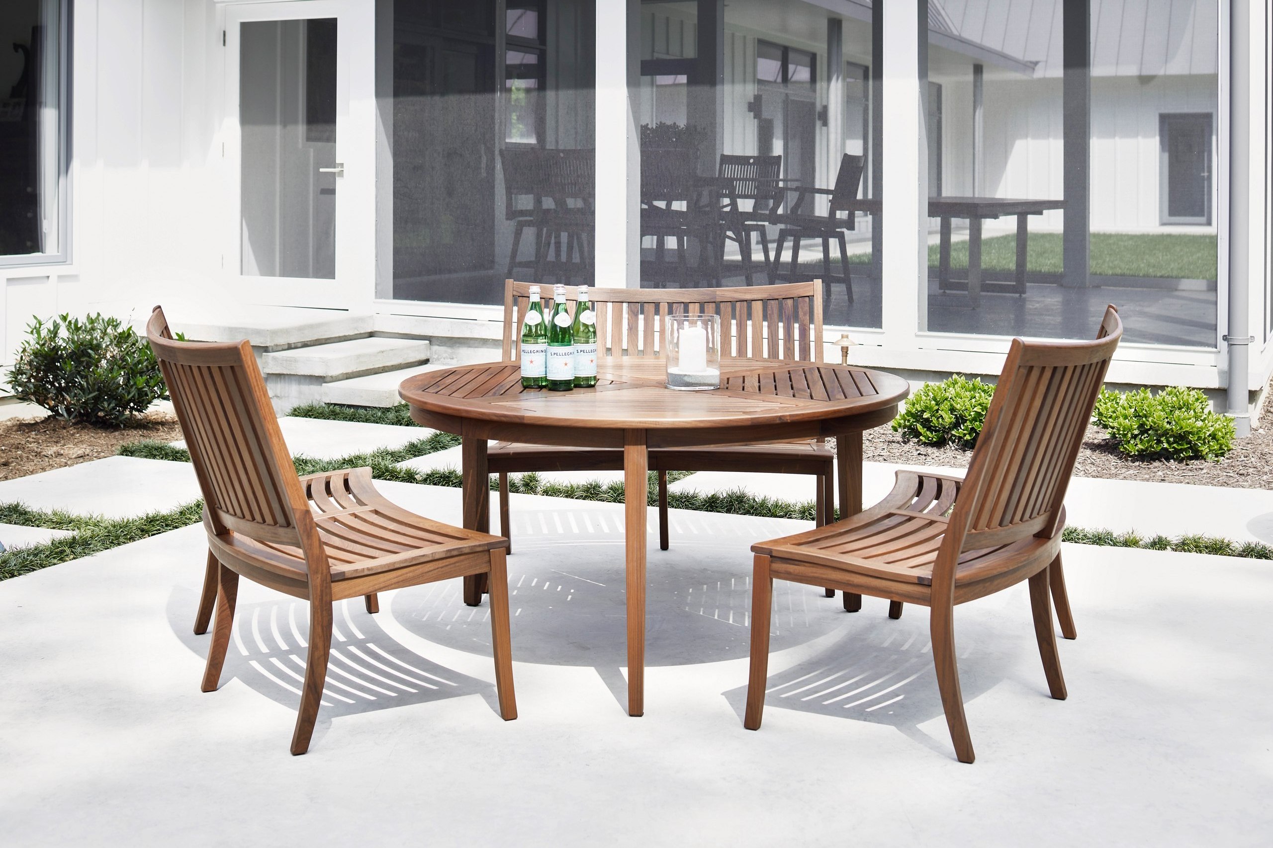 Richard set of curved garden benches in solid teak wood with a round table and walnut finish.