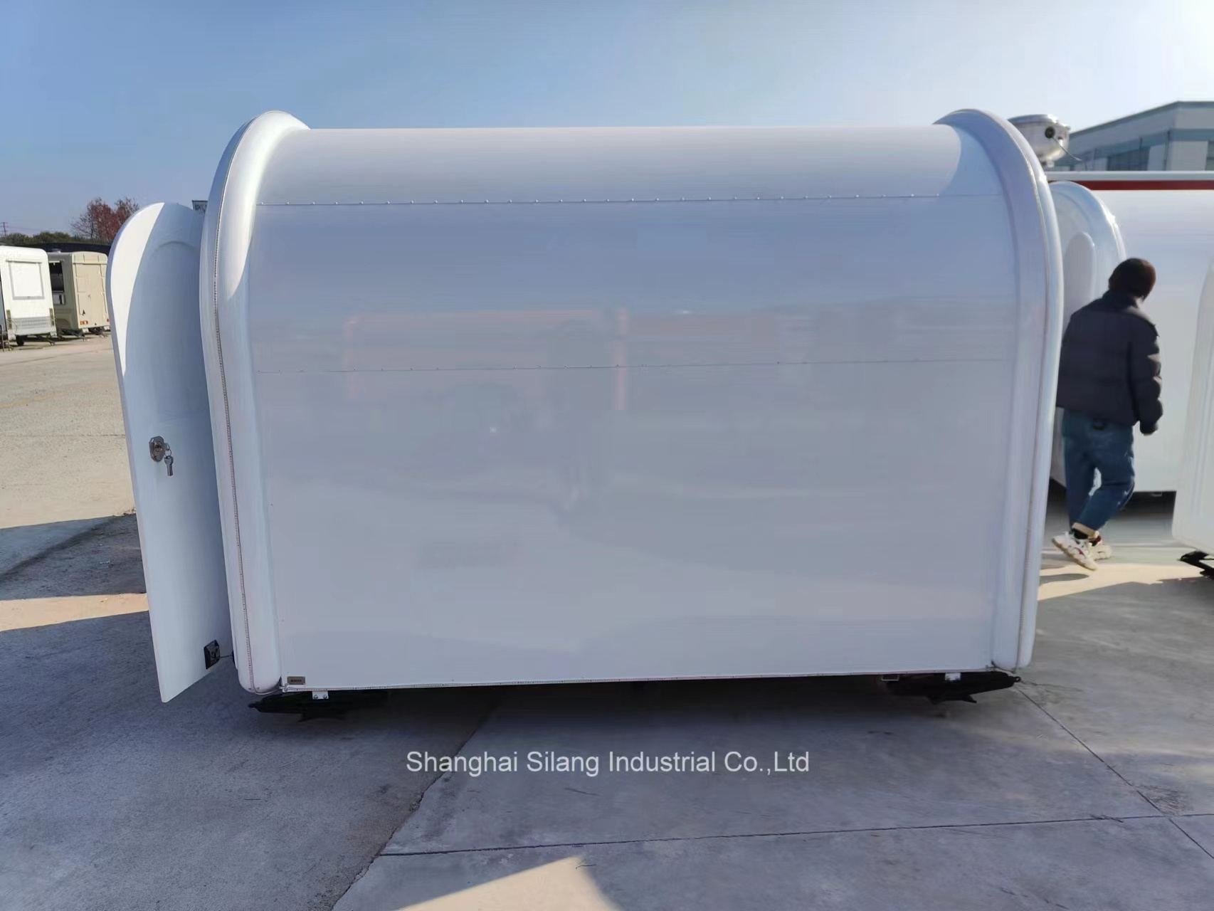 A food truck trailer with white fiberglass and right angle sales windows and air conditioning