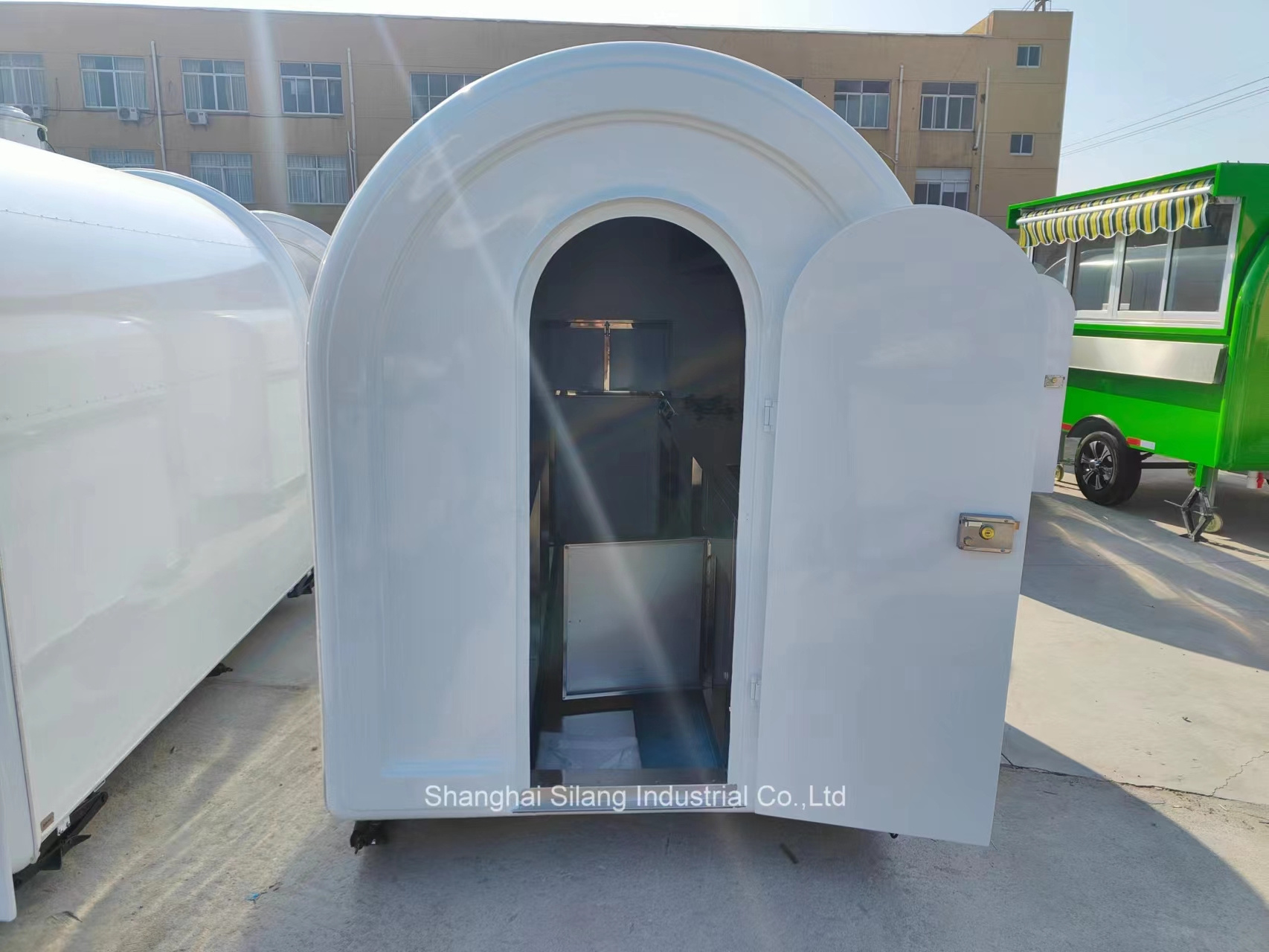 A food truck trailer with white fiberglass and right angle sales windows and air conditioning