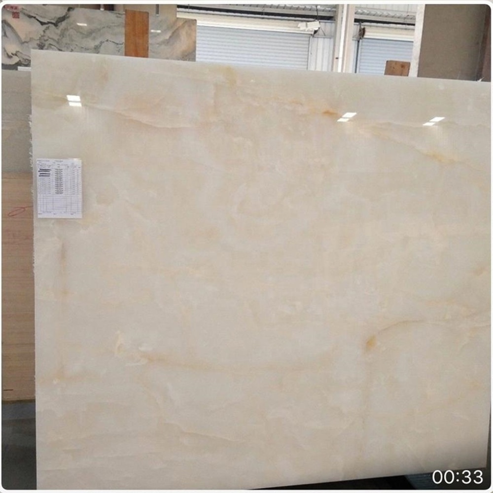 Backlit white jade onyx marble polished panel with tiny yellow gold veins