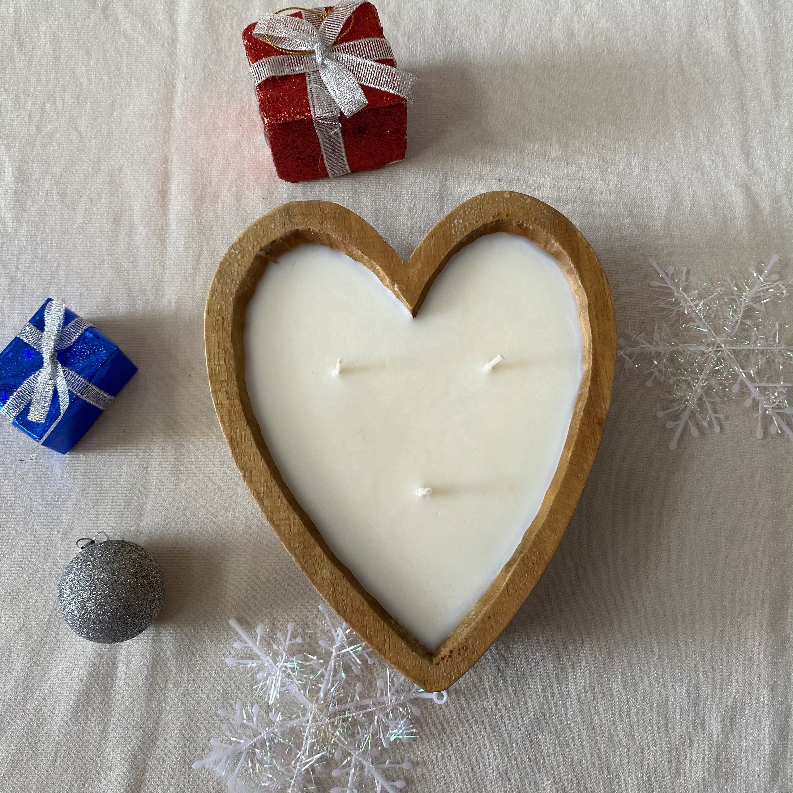 Hand-poured coconut scented candles in hearted shape wooden bowls from Vietnam