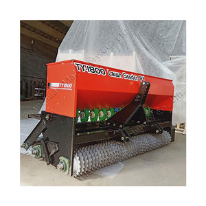 Lawn seeder for agriculture. Tractor drives grass seed planter