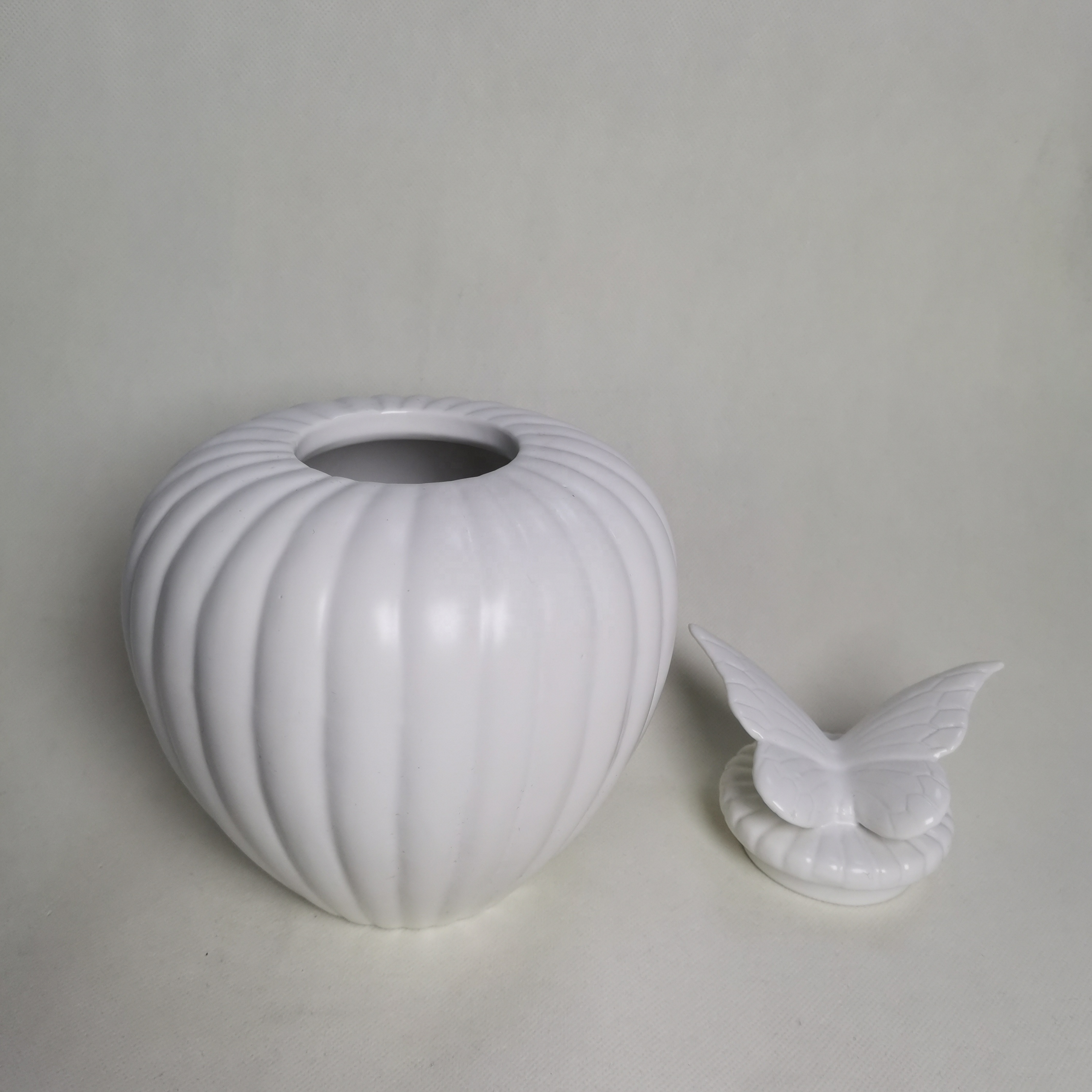 Ceramic pet urn with textured butterfly wing lid