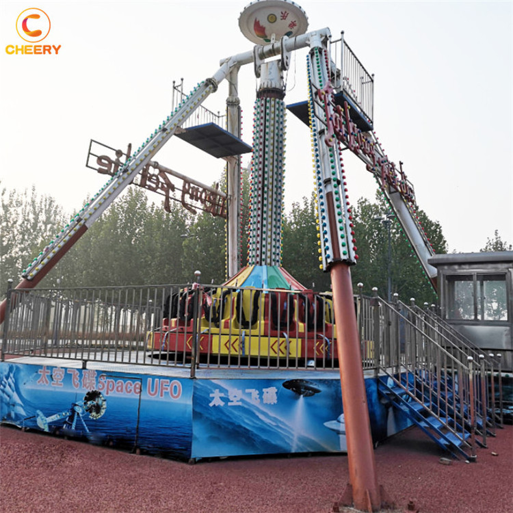 Fairground outdoor amusement park thrilling rides space UFO giant frisbee hammer big swing pendulum